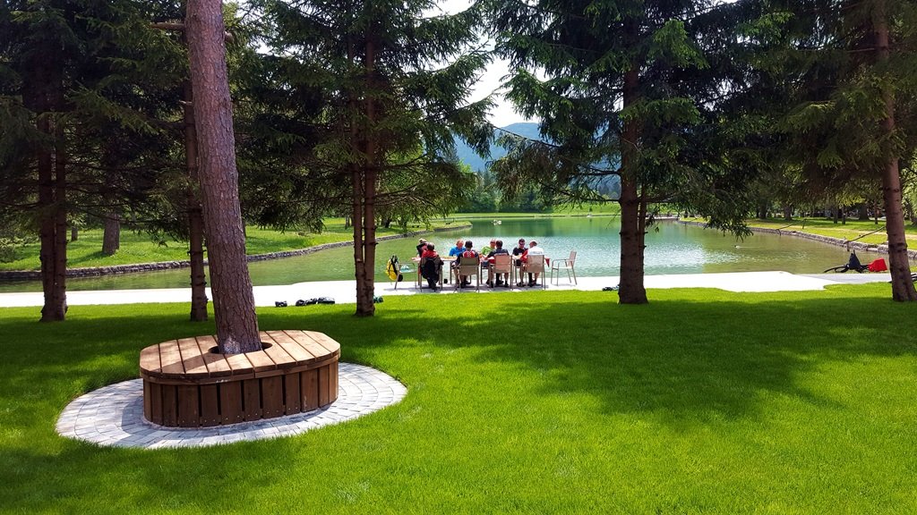 A tó mellett élénkzöld fűszőnyeg csábítja a vendégeket pihenésre