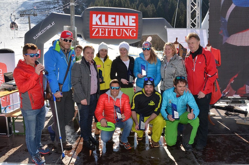 A 6. Schlag das Ass - A világ leghosszabb sífutóversenye büszke győztesei trófeáikkal és a sérült házigazdával Armin Assingerrel Forrás: www.nassfeld.at/hu