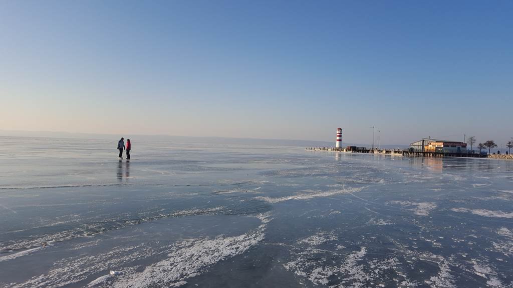 Podersdorf am See védjegye, a világítótorony és korcsolyázók idillikus képe tölti be a tájat.