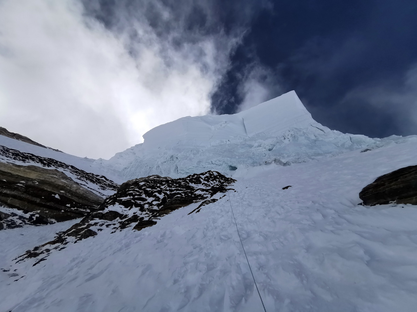 Az ember feje fölött kifelé dőlve tornyosul a 120 m magas jégfal, a Palacknyak-kuloár Forrás: Eseményhorizont
